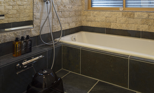 浴室：天然石の壁・床とホーロー浴槽
